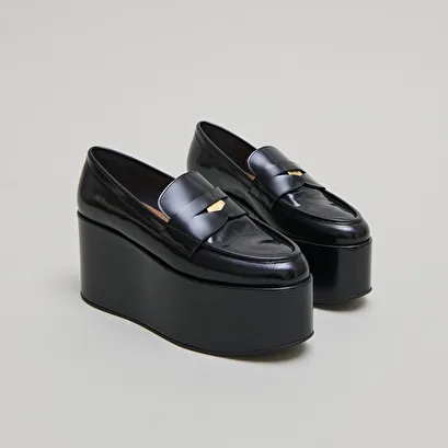 Platform loafers in black glazed leather