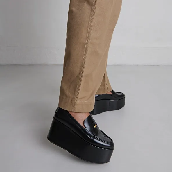 Platform loafers in black glazed leather